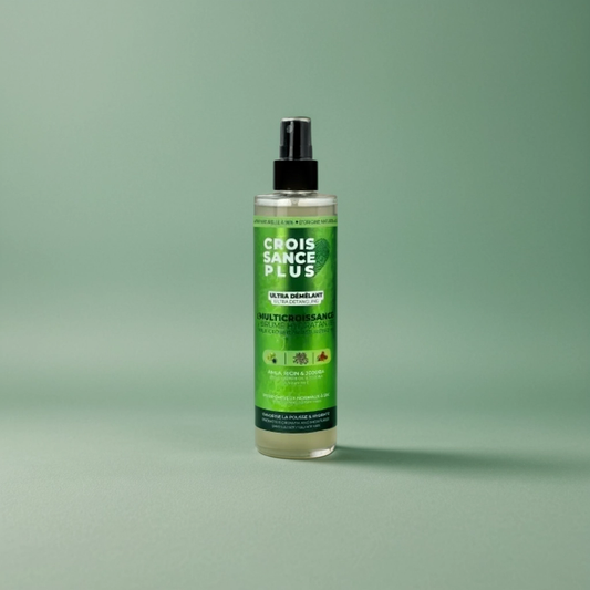 A bottle of Croissance Plus - Multricroissance Brume Hydratante 300ml hair growth enhancing mist by JS Organics with a green label, placed against a green background.