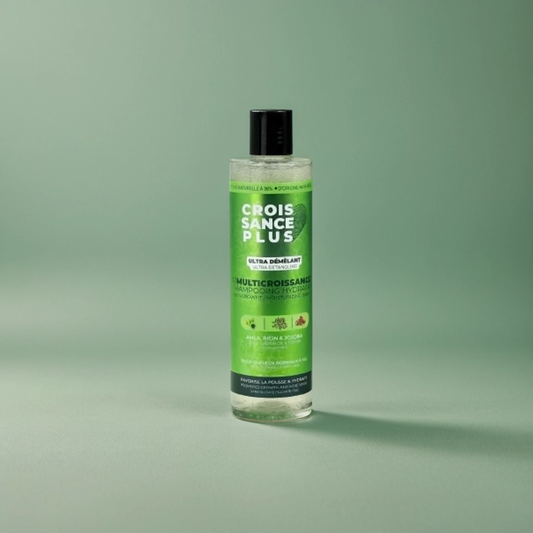 A clear bottle of Croissance Plus Multicroissance Shampoo by JS Organics with a green label, placed against a green background.