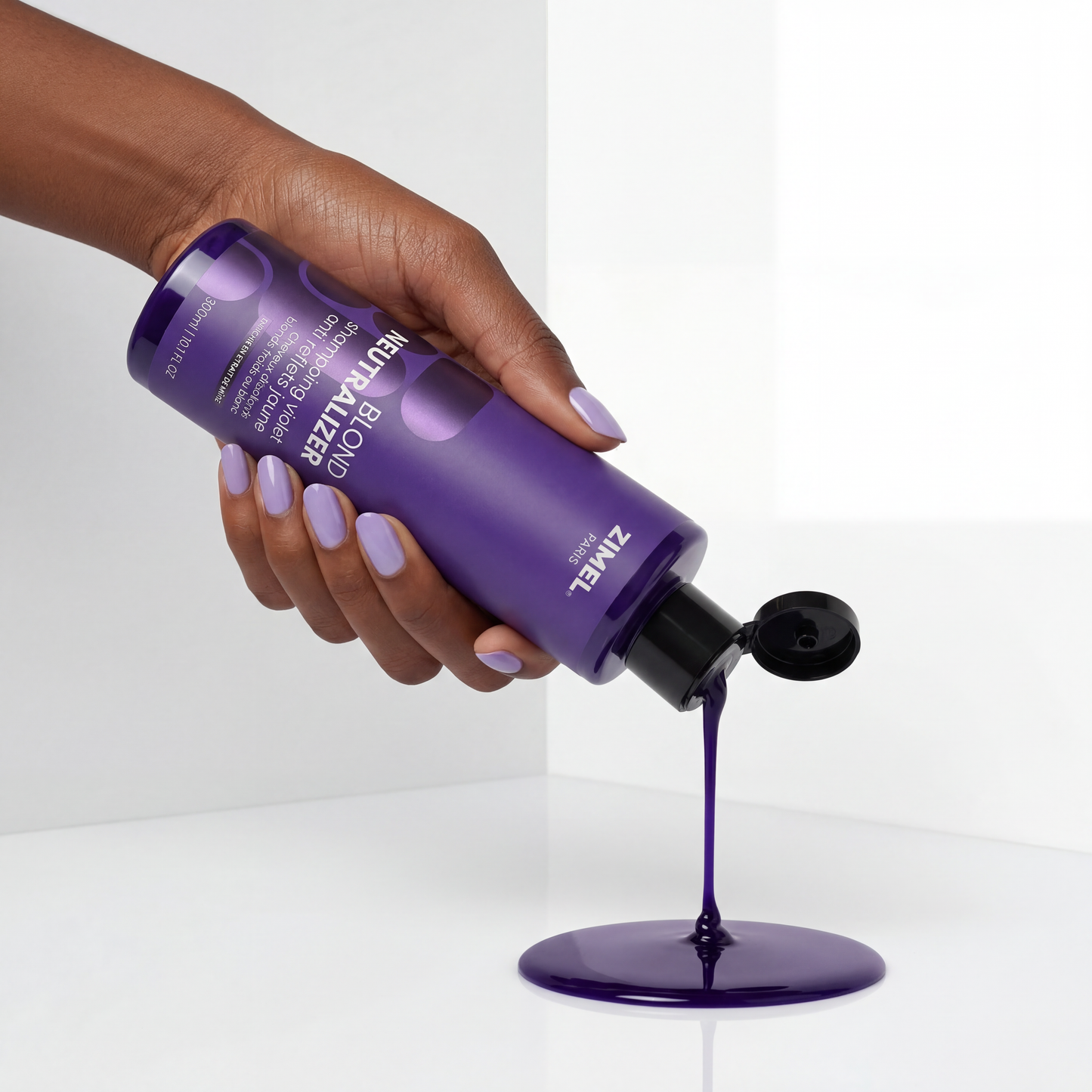 Hand holding a Zimel Paris BLOND NEUTRALIZER Shampoing Violet Anti Reflets Jaune 300ml bottle by JS Organics, pouring its contents onto a white surface.